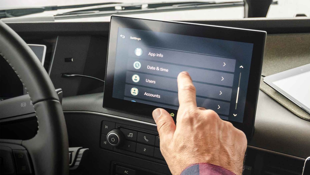 Ein im Fahrerhaus sitzender Fahrer bedient den neuen Touchscreen des zusätzlichen Displays