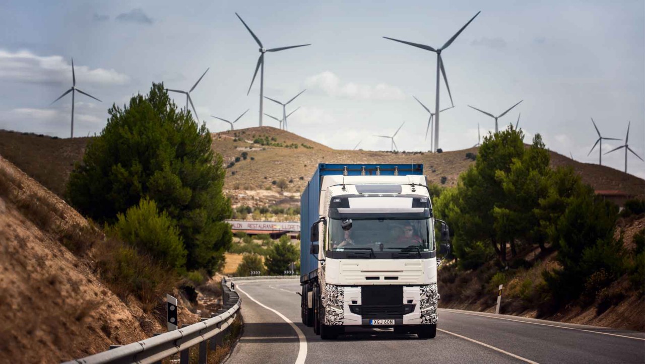 Ein Testfahrzeug unterwegs in Spanien mit Windkraftanlagen im Hintergrund
